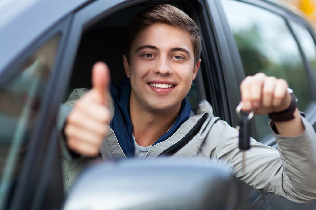 Man doing thumps-up in car