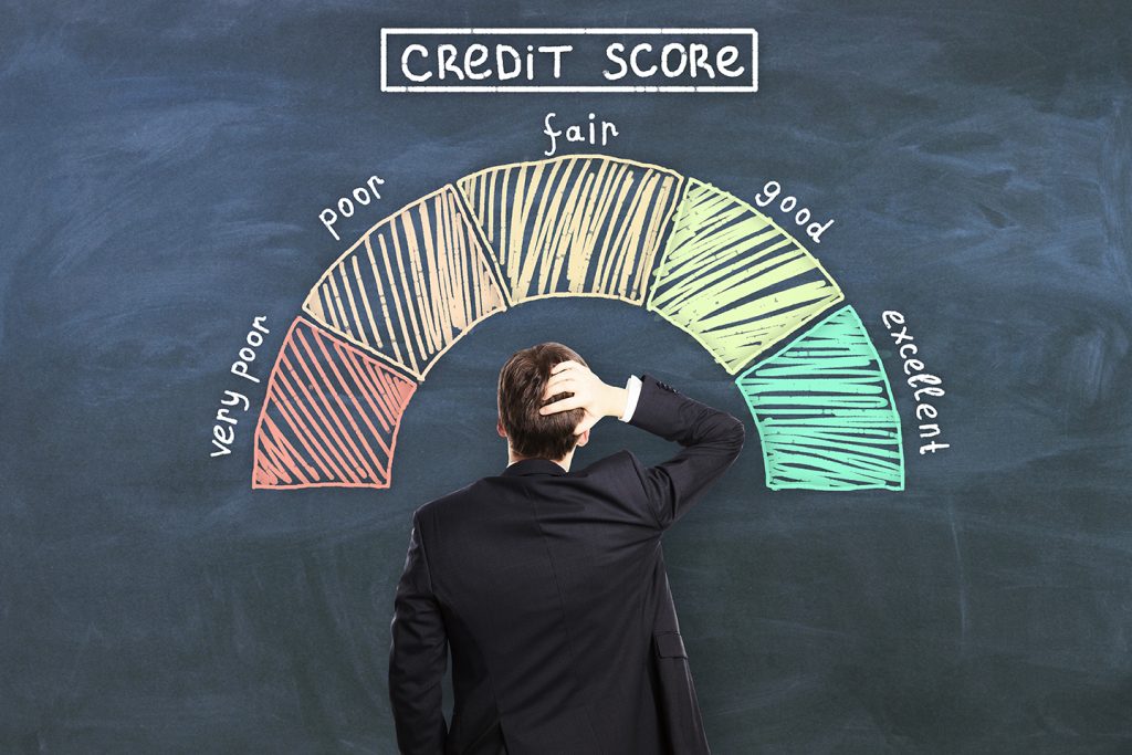 Credit score concept with pensive man back in front of chalkboard with credit score levels